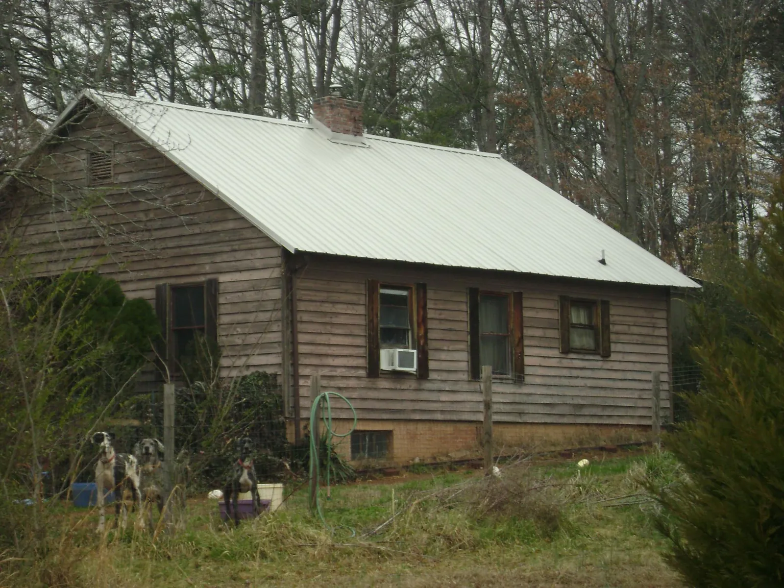 White metal roof on an old wood sided farmhouse, from a Metal Roof Installation job in Indianola